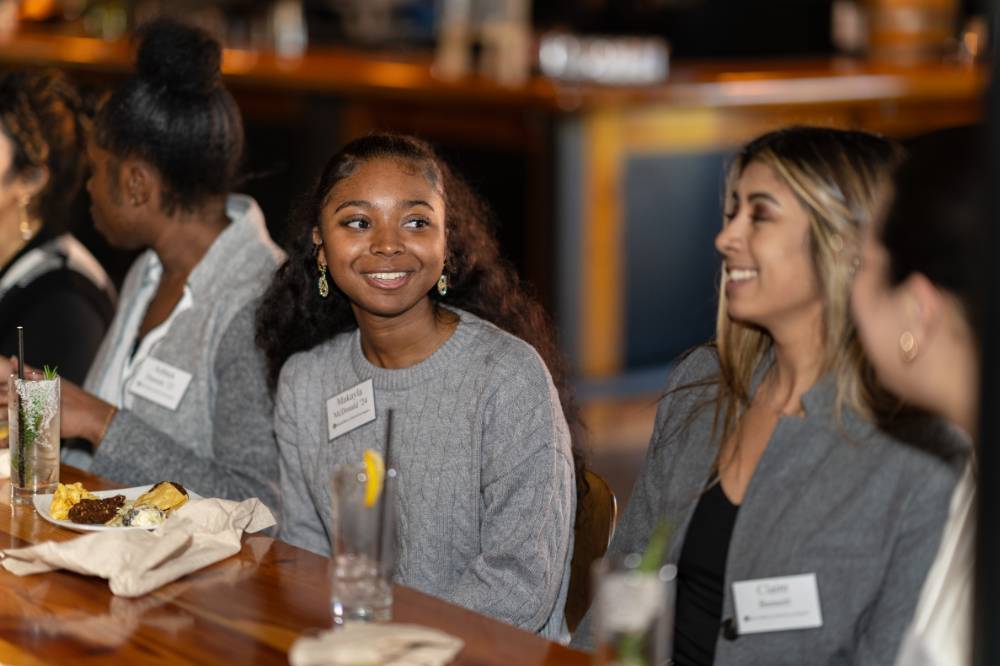 Three event attendees sitting and talking with each other